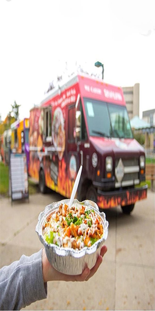 The Rocky Mountain Pizza+ food truck, with a bowl of chicken and rice in the foreground